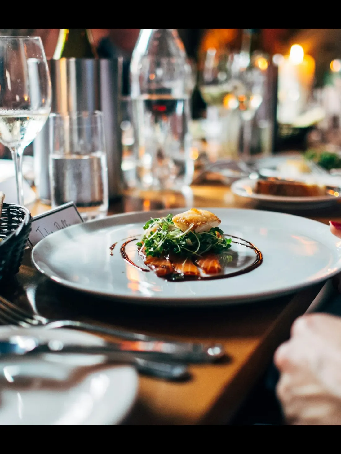 A server setting a restaurant table during evening service